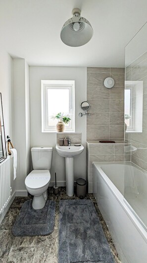 A modern bathroom with a toilet, sink, and bathtub. - Cotswold Green - Sleeps 5 - Free EV Charge (Tewkesbury)