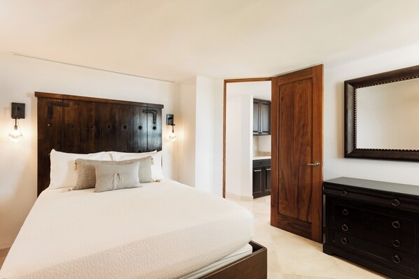 Un dormitorio con una cama grande, un aparador y un espejo en la pared.