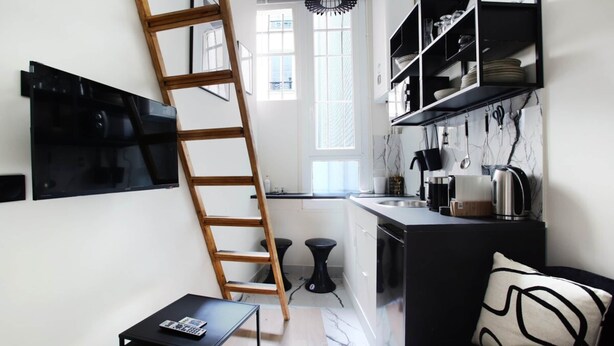 A compact kitchen with a wooden ladder, black shelves, and a marble backsplash. - Studio Center of Paris Grand/boulevard (Paris)