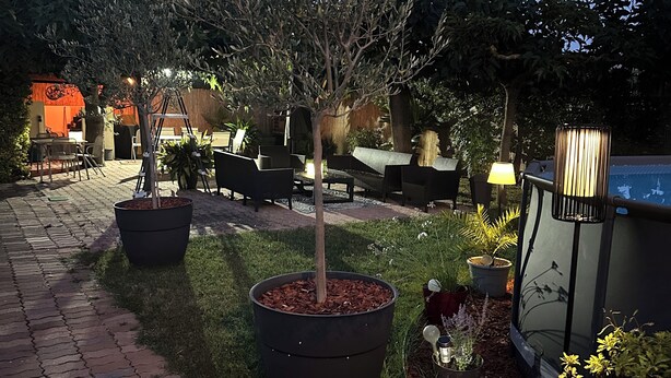 A paved outdoor area with potted plants, a seating area with chairs and tables, and a poolside area with a lamp. - Villa with Private Pool – Grau d’Agde – 6–8 Guests – Beach – AC (Agde)