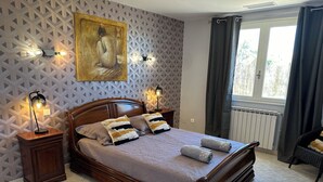A neatly made bed with pillows and a blanket, a wooden headboard, a painting on the wall, and a window with curtains. - Villa with Private Pool – Grau d’Agde – 6–8 Guests – Beach – AC (Agde)