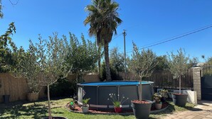 A backyard with a swimming pool, potted plants, and a wooden fence. - Villa with Private Pool – Grau d’Agde – 6–8 Guests – Beach – AC (Agde)