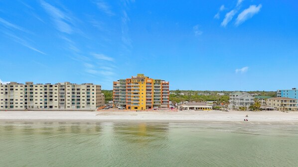 A beachfront hotel with multiple floors, balconies, and a beachside location.
