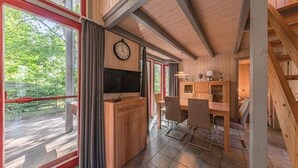 Ambiente in legno con angolo cottura, tavolo e sedie.