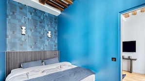 Una camera da letto moderna con un letto, una TV a parete e un soffitto in legno.