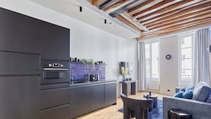 Una cucina moderna con mobili scuri, forno integrato e zoccolo viola.