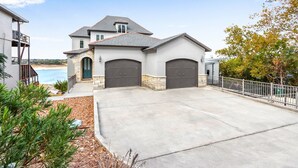 A two-story house with a garage, a balcony, and a view of the beach. - Lakeside Dreamhouse I Lake, Hot tub, Dogs (Canyon Lake)