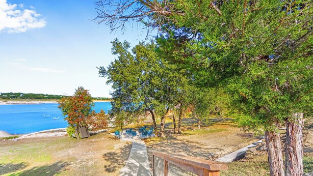Un sentier côtier bordé d’une clôture en bois, d’arbres et offrant une vue sur la mer.