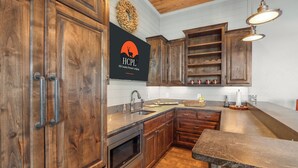 A kitchen with wooden cabinets, a stainless steel sink, and a microwave. - Lakeside Dreamhouse I Lake, Hot tub, Dogs (Canyon Lake)