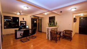 A spacious room with a desk, chairs, a small table, and a plant. - Hotel El Cerro (Liberia)