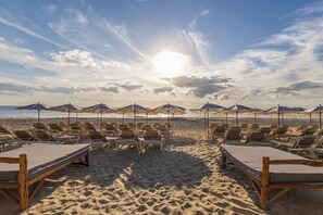På stranden, hvidt sand, gratis strandhytter, liggestole