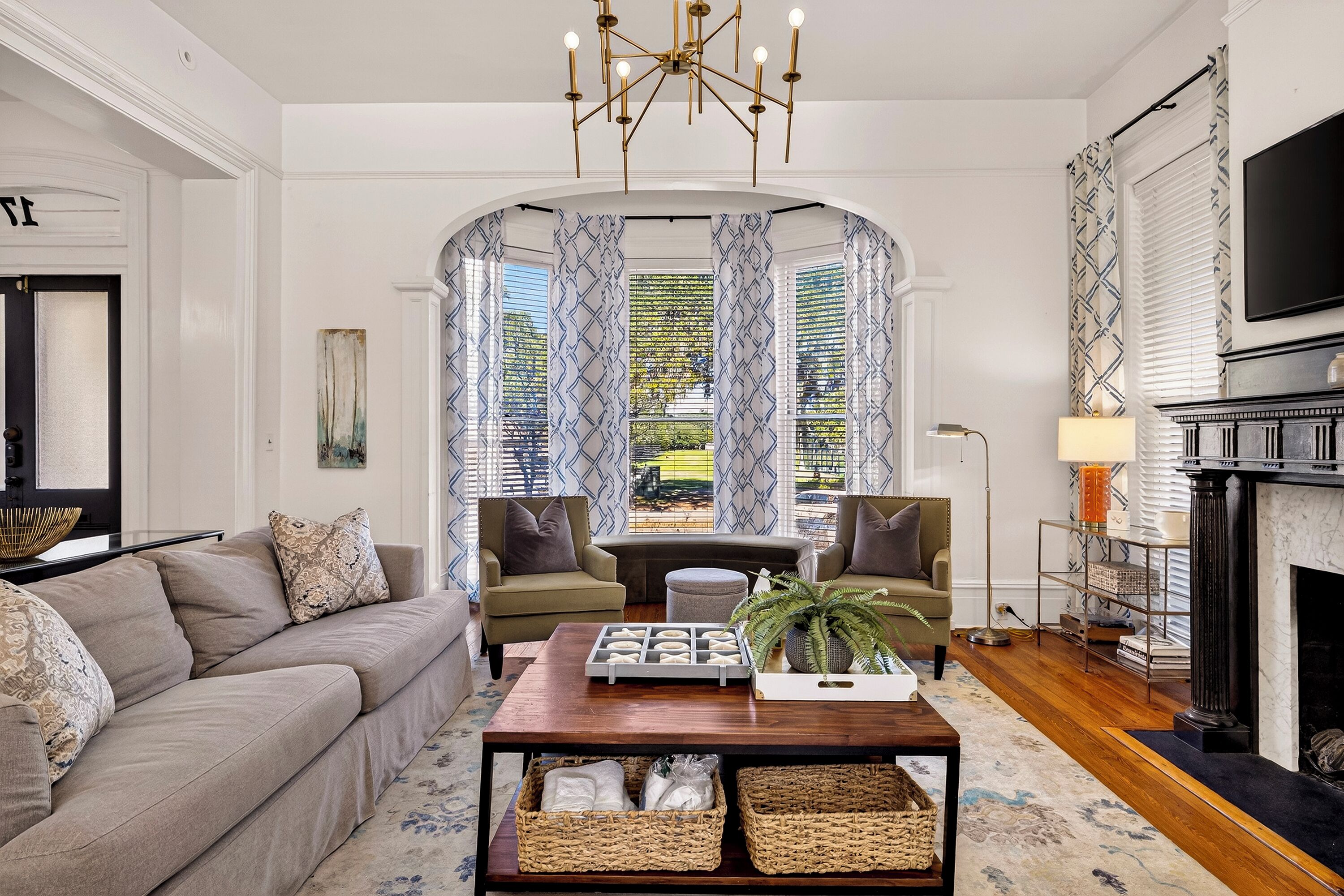 A living room with a sofa, armchairs, a coffee table, and a fireplace.
