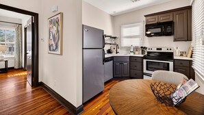 Una cocina moderna con refrigerador, estufa, microondas y un comedor con mesa.