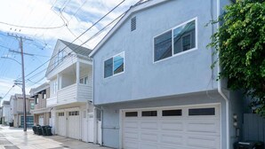 Uma rua residencial com casas, uma garagem e um poste de eletricidade.