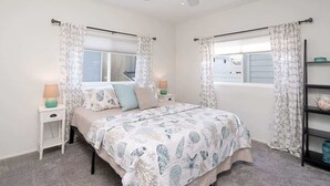A bedroom with a bed, two nightstands, a ceiling fan, and a window with curtains. - 304 Ruby B | Balboa Island Charmer (Newport Beach)