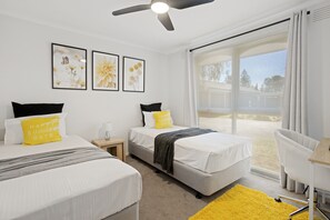 A hotel room with two beds, a window with a view, and a ceiling fan. - Rose by the Bay  Coastal Getaway in Tootgarook (Tootgarook)