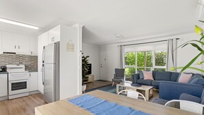 Eine moderne Küche mit weißen Schränken, einem eingebauten Ofen und einem Edelstahl-Kühlschrank.