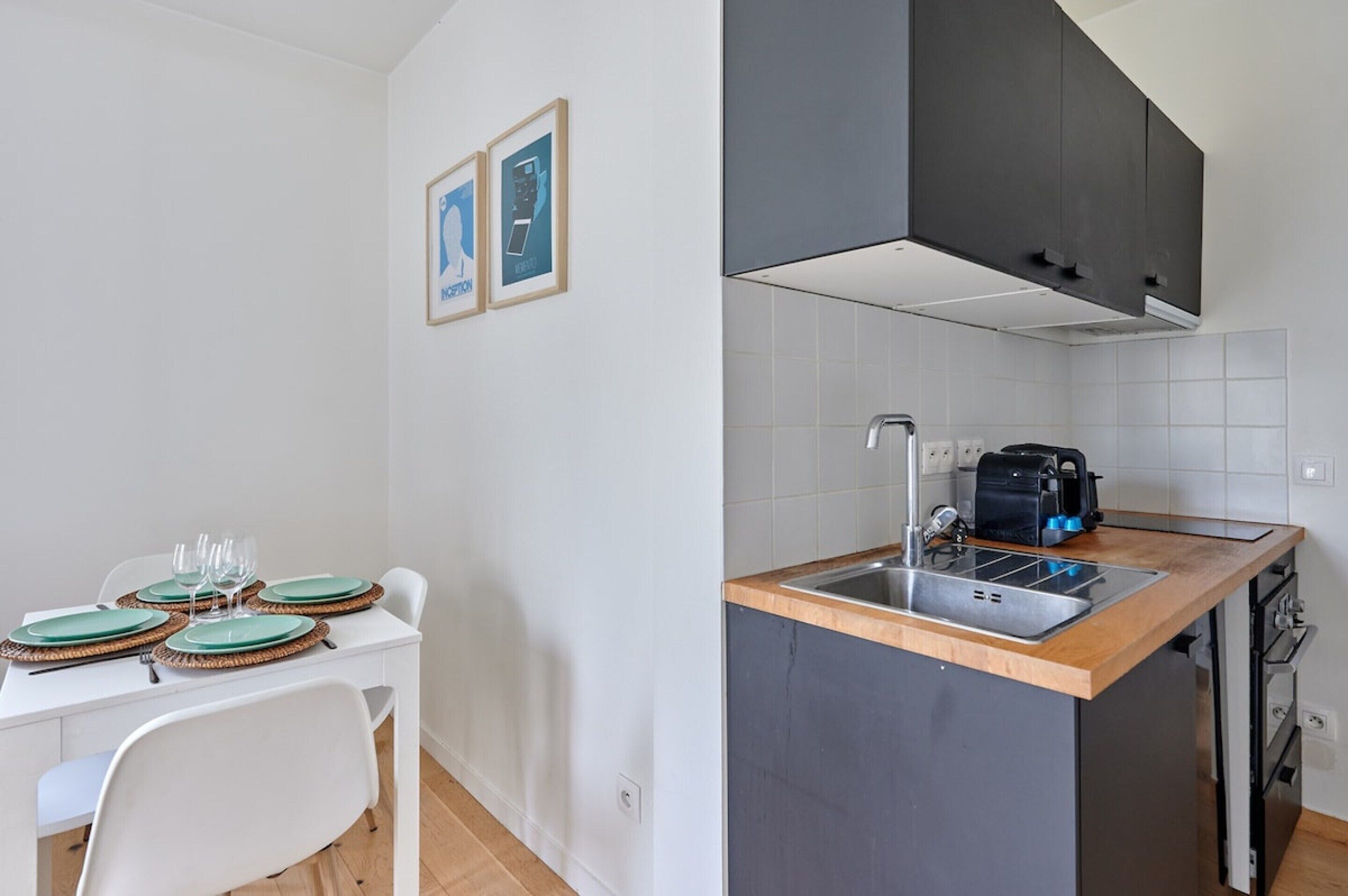 A compact kitchen with a built-in sink, a toaster, and a dishwasher.