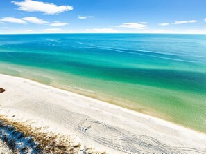 Ein Strand mit klarem türkisblauem Wasser und einem sandigen Ufer.