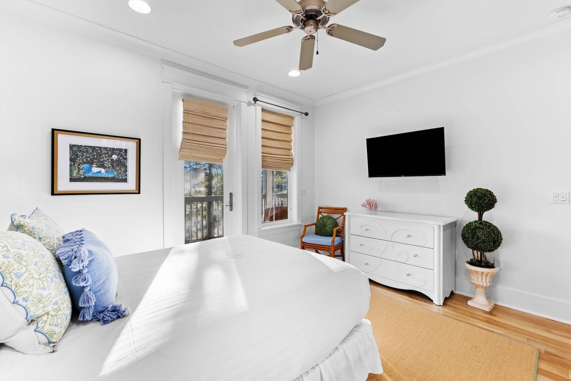 A bedroom with a bed, a dresser, a television, and a window with blinds.