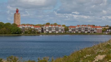 A waterfront hotel with a prominent tower and multiple buildings with red roofs.