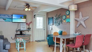 A dining area with a wooden table, red and blue chairs, and a ceiling fan. - ☀️4BR-1 Block from Beach-Pet Friendly-Sea Hook☀️ (St. Joe Beach)