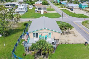 Standalone house with a gabled roof and covered porch, situated on a well-maintained lawn.
