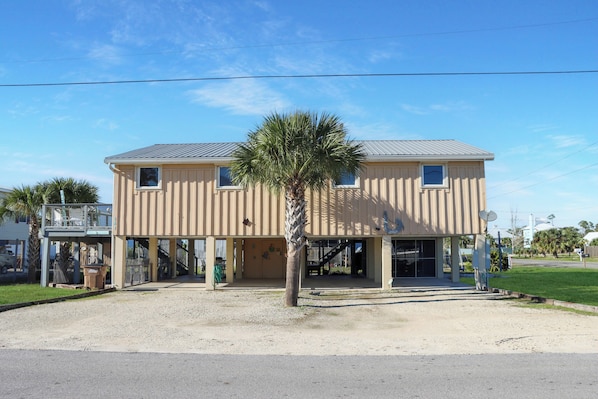 Stunning two-story building with a central entrance and covered walkway, set amidst a lush lawn and paved driveway.