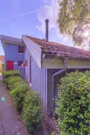 A building with a red door, a chimney, and a gutter. - Ferienhaus im Skandinavischen Stil (Mirow)