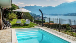 Una piscina con vistas a montañas y un lago.