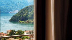 Vista de un lago con montañas al fondo y una pequeña isla con edificios.