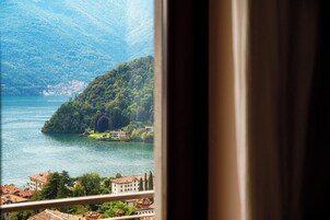 Vista di un lago con montagne sullo sfondo e una piccola isola con edifici.