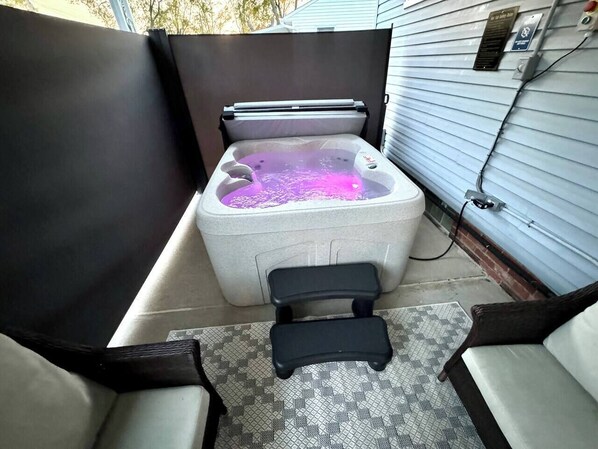 Ein Whirlpool mit integriertem Sitz und einem kleinen Tritt für den Zugang.