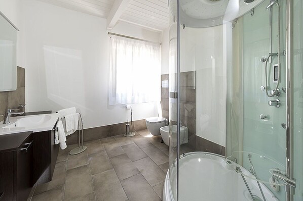 A modern bathroom with a glass-enclosed shower, a white sink, and a toilet. - Villa in Agrigento Near Valley of the Temples (Agrigento)
