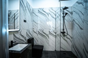 Deluxe driepersoonskamer, patio | Badkamer | Een douche, handdoeken, toiletpapier