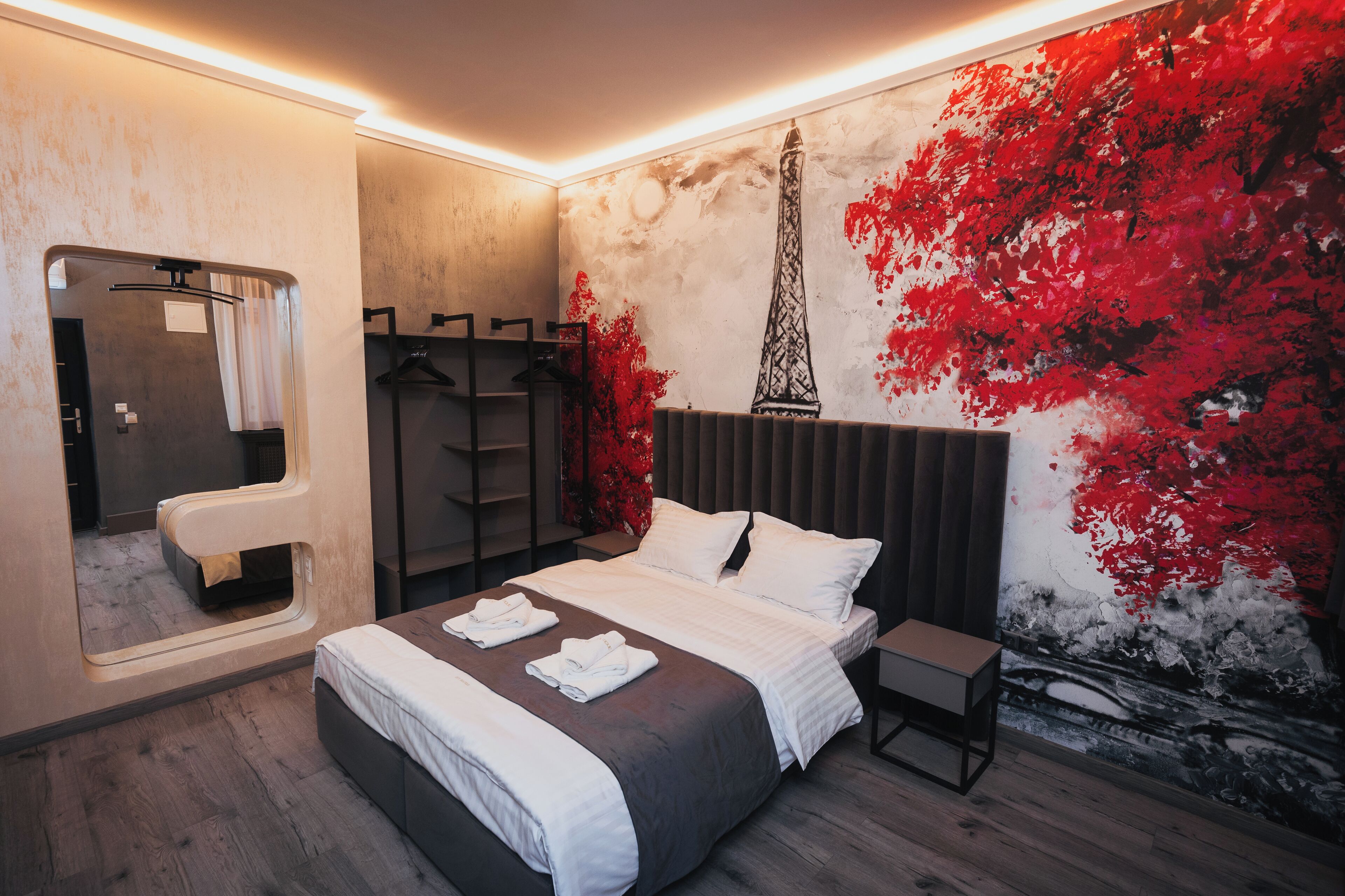Una camera da letto moderna con un letto grande, un comodino, uno specchio e un armadio.