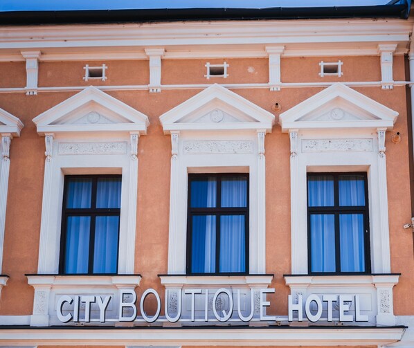 A building facade with three windows and a sign that reads "CITY BOUTIQUE HOTEL". - City Boutique Hotel Reghin (Reghin)