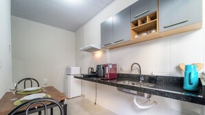Una cocina compacta con comedor, equipada con microondas, tostadora y cafetera.