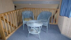 A corner room with two wicker chairs and a small round table. - Ferienhaus im Ferienpark Mirow (Mirow)