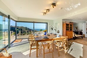 A dining area with a large table, chairs, and a telescope. - 6 Bed in Lee (oc-d30327) (Ilfracombe)