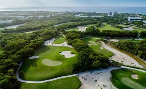 Golfers can enjoy a challenging round amidst lush greenery and scenic ocean views.