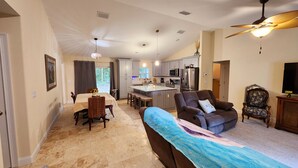 A spacious living area with a dining table, a sofa, and a TV.