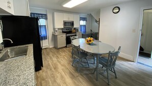 Una cocina compacta con una mesa de comedor, sillas y un microondas.