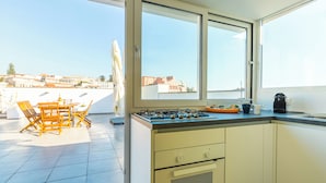 Een moderne keuken met uitzicht op de stad, een eethoek met houten meubels en een groot raam.