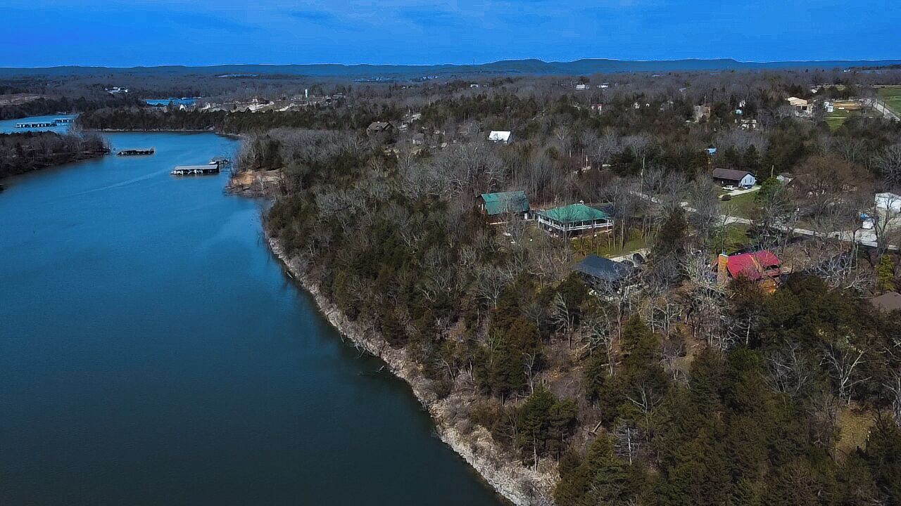 An aerial view of a riverside area with houses and boats.