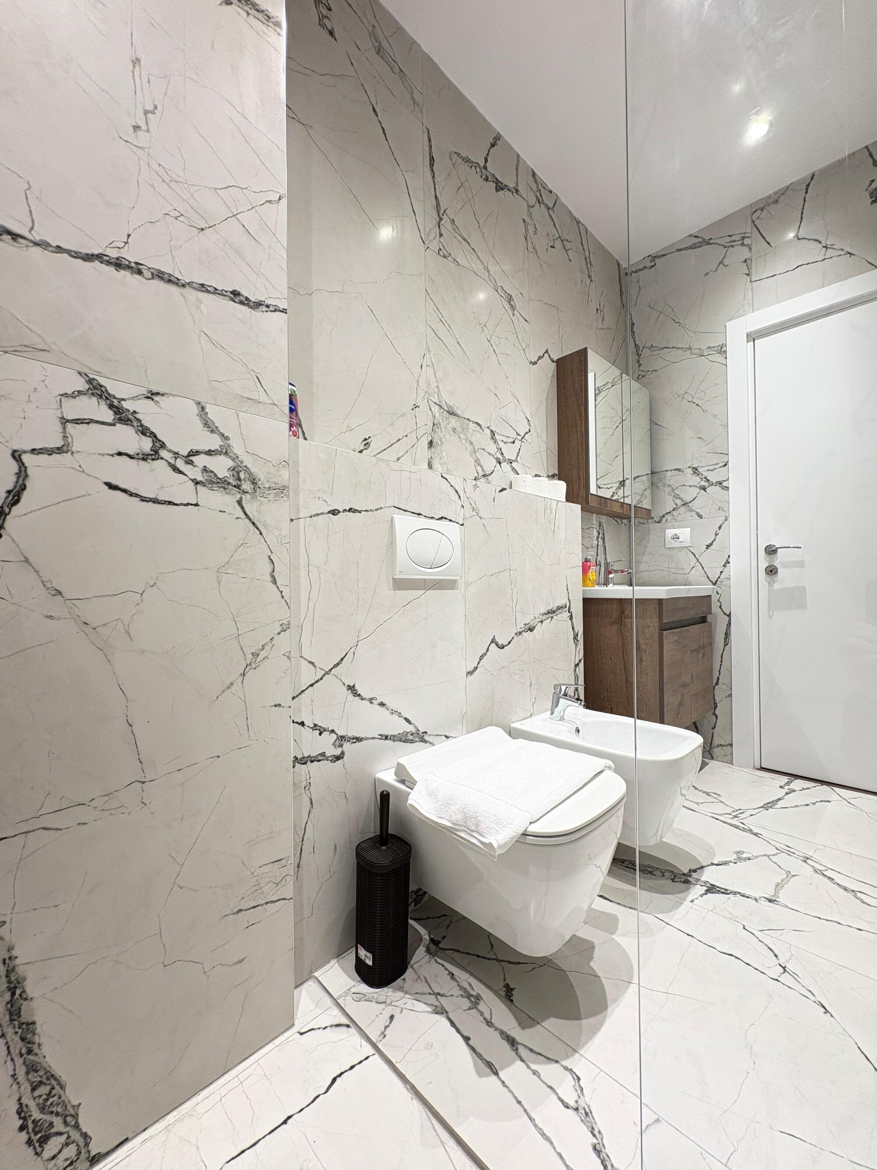 Een moderne badkamer met een vrijstaand bad, toilet en wastafel.