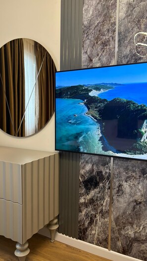Televisor montado en la pared con vista a un paisaje costero.