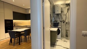 Eine moderne Küche mit Essbereich, Backofen und Marmorfliesenspiegel.
