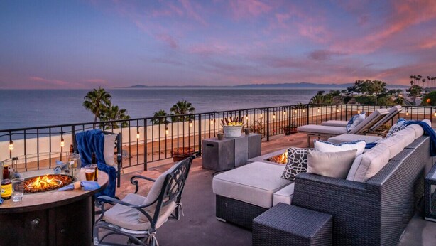 A terrace with outdoor seating, a fire pit, and a view of the ocean at sunset. - SeaCliff - Harbor View - Oceanfront Luxury in Santa Barbara (Santa Barbara)