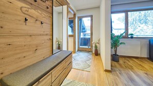 Un intérieur moderne avec un banc en bois, un miroir et une vue sur l’extérieur.